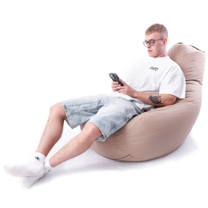 Mężczyzna siedzący na fotelu grucha EcoYoung Outdoor w kolorze beżowym, z telefonem w ręku – wygodna pufa typu worek sako do relaksu.