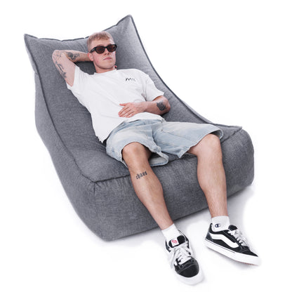 Mężczyzna relaksujący się na szarej leżance EcoYoung HORIZONT z tkaniny typu len.