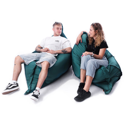 Dwie osoby siedzące na dużych pufach outdoorowych w kolorze butelkowej zieleni, idealnych do relaksu w ogrodzie lub na tarasie.