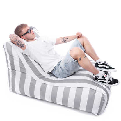 Mężczyzna odpoczywający na biało-szarej leżance Stripe w szerokie pasy – nowoczesny fotel outdoorowy EcoYoung