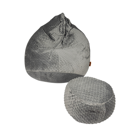 Miękka, sensoryczna pufa Minky z wypukłymi kropkami w kolorze szarym w zestawie z podnóżkiem w tym samym kolorze. 