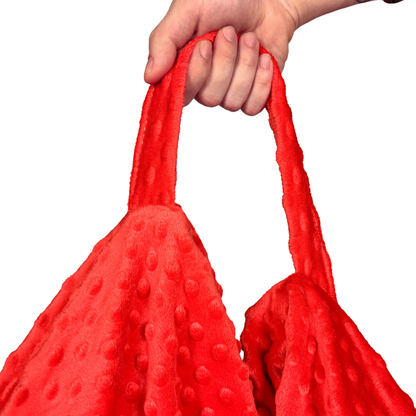 Rączka czerwonego, sensorycznego fotela Minky w wypukłe kropki. 